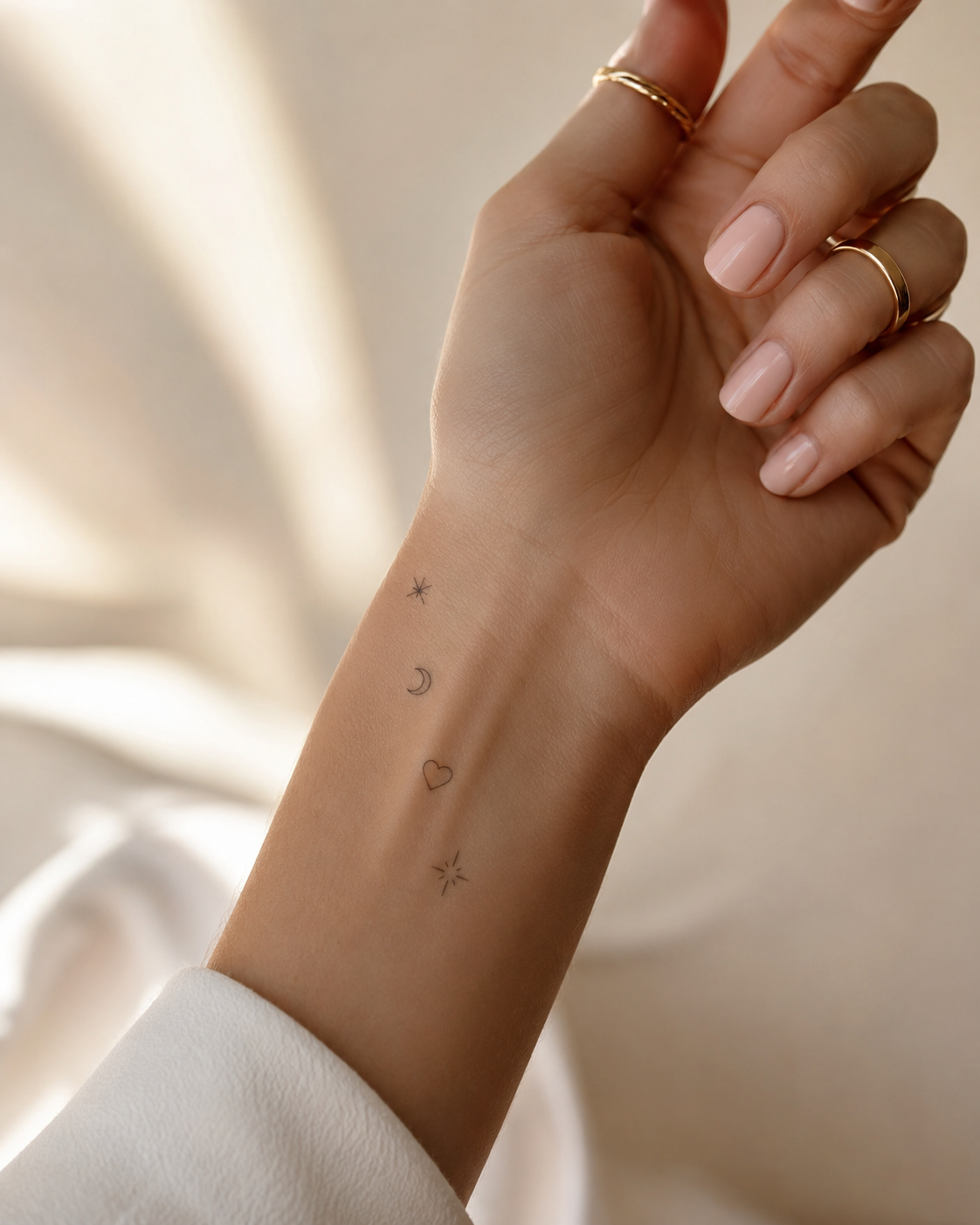 Mini symbol tattoos op hand en pols